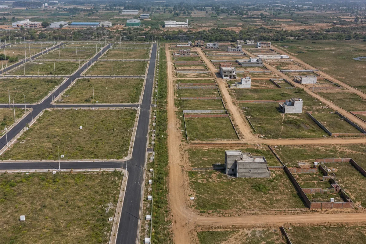 Two Bhiwadi plotted developments with visibly different roads, drainage and utility infrastructure
