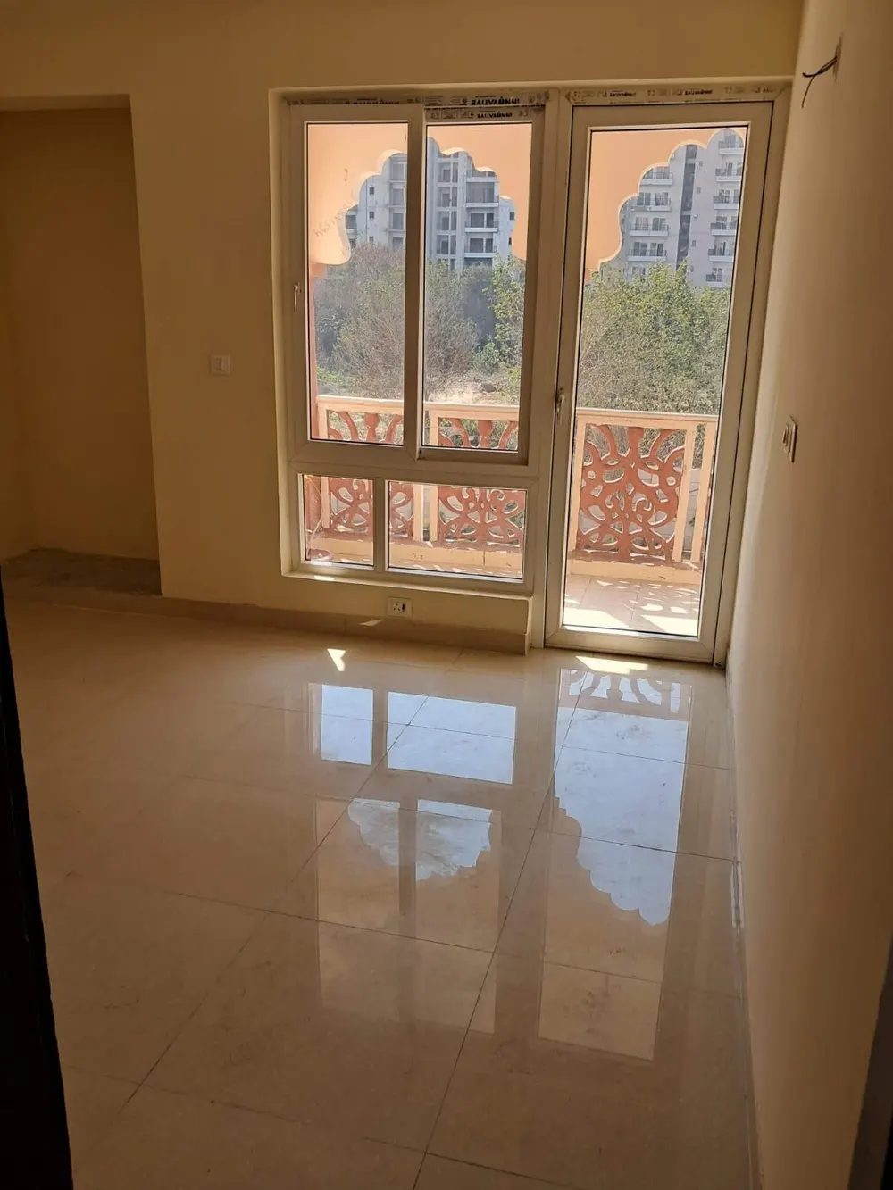 Bedroom with balcony, jharokha-style railing, this 3 BHK flat at HFL Presidency Estate, Bhiwadi