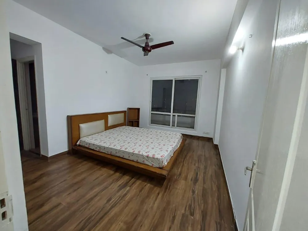 Bedroom with a ceiling fan and a sliding balcony door, this 3 BHK flat at MVL Coral, Alwar Bypass Road, Bhiwadi