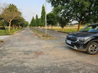 Unmade internal road running between unbuilt plot rows in Chanderlok City, Tijara