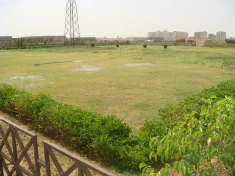 Landscaped park inside Dwarkadhis City — this plot overlooks a park like this