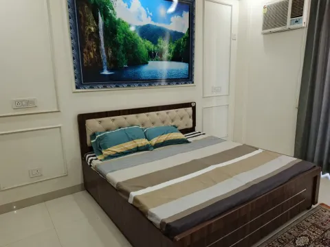 Furnished double bedroom with a window air conditioner in a Madhuvan Residency villa, Bhiwadi