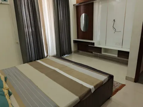 Bedroom with full-height curtains and a built-in wardrobe unit in a 5 BHK villa, Madhuvan Residency, Bhiwadi
