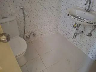 Bathroom with the wash basin still carrying its factory sticker, this flat at MVL Coral, Bhiwadi