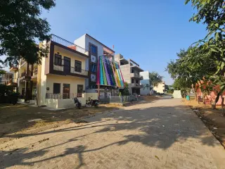 Paved internal street lined with completed houses in Omaxe Green Meadow City, Bhiwadi