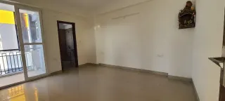 Empty hall with balcony door and bathroom doorway, this 3 BHK flat at The Cubix, Dharuhera