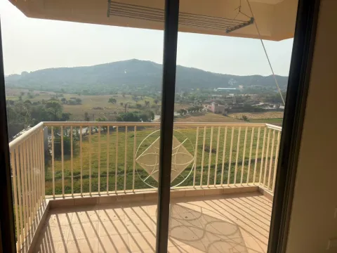 Balcony of an Ashiana Tarang flat in Bhiwadi looking across open fields to the Aravalli hills