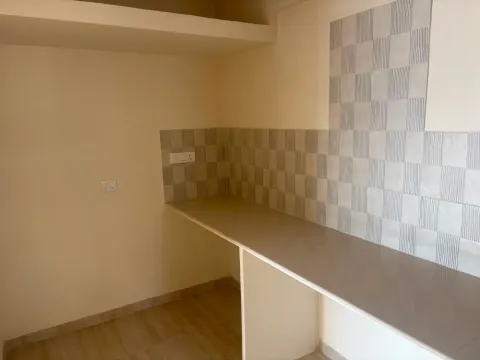 Kitchen counter with patterned wall tiles in an Ashiana Tarang flat, Bhiwadi