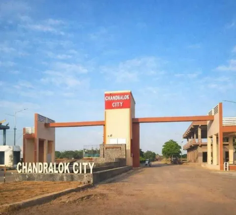 Gateway tower lettered Chandralok City above the approach road into the township, Tijara