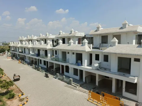 Paved internal road running along a terrace of white villas in Madhuvan Residency, Bhiwadi