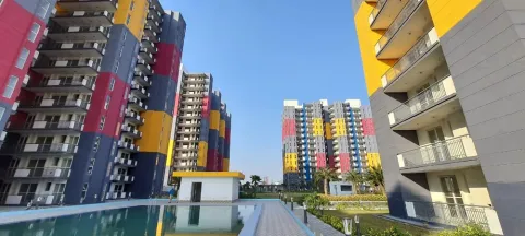 Swimming pool between the colour-panelled towers of The Cubix, Sector 23 Dharuhera